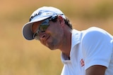 Adam Scott plays out of the bunker at The Open