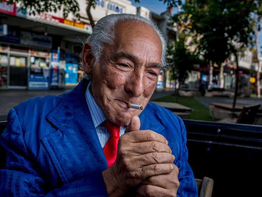 John Halilovich, who wears a suit, lights up cigarette on a Footscray Street.