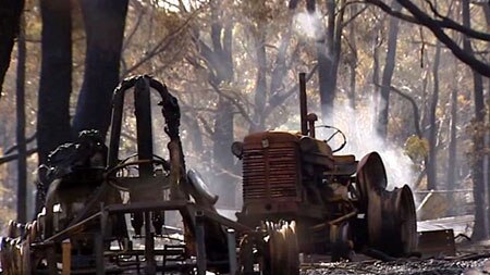 Farming equipment smoulders after a bushfire in Victoria.