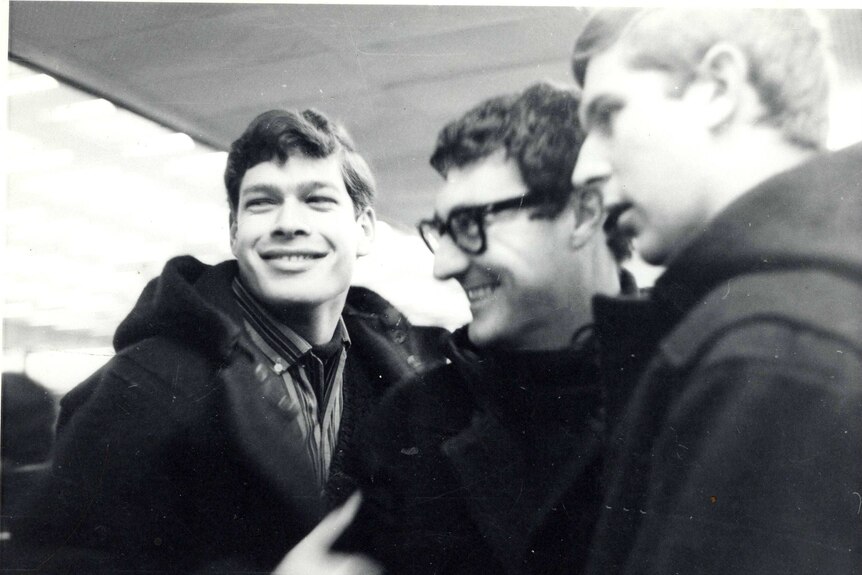 A black and white photo of three young men, smiling
