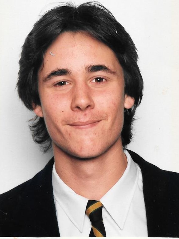 A scan of an old high school photograph, portrait of Jarrod wearing a school uniform.