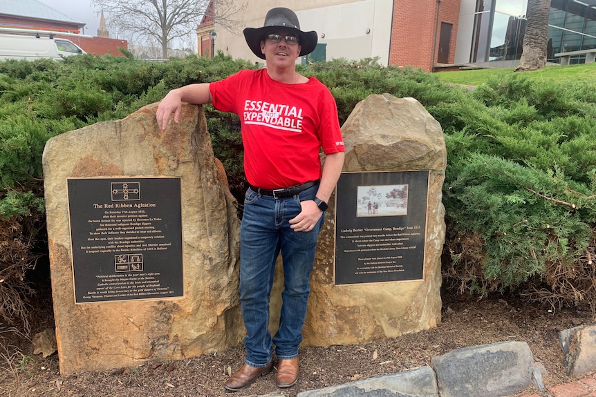 A man standing next to a memorial.