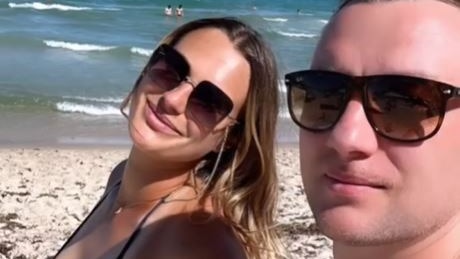 Tennis player Aryna Sabalenka and partner Konstantin Koltsov on a beach.