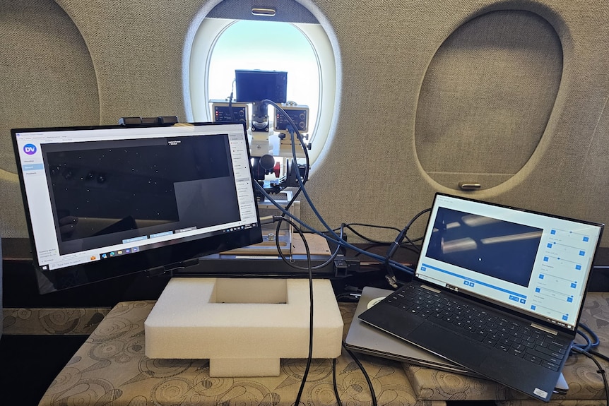 Computers and scientific equipment on a desk on a plane