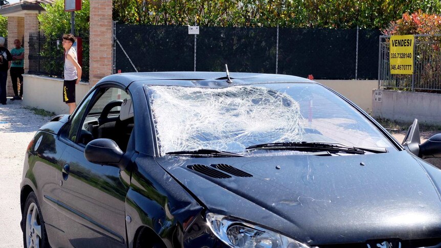 A small car with a caved-in windscreen.