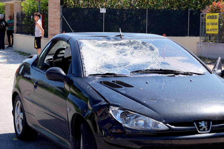 A small car with a caved-in windscreen.