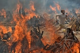 A man runs to escape heat emitting from the multiple funeral pyres.
