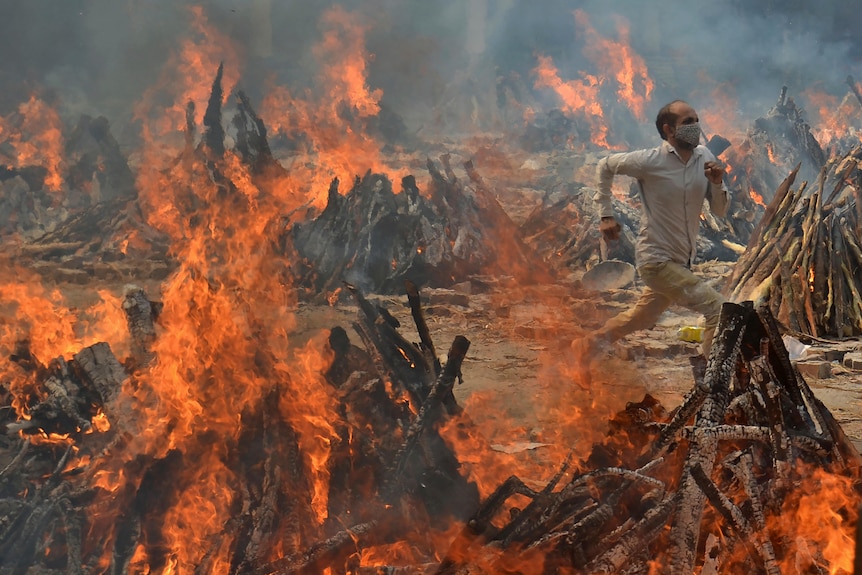 A man runs to escape heat emitting from the multiple funeral pyres.