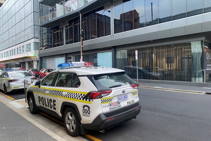 Two police cars outside a large hotel
