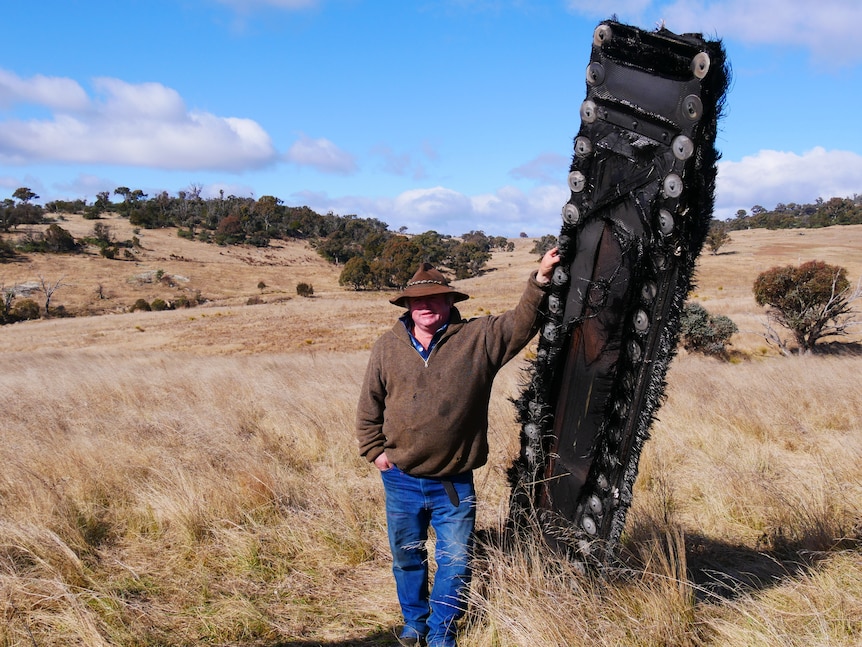 a man leans against a piece of space junk