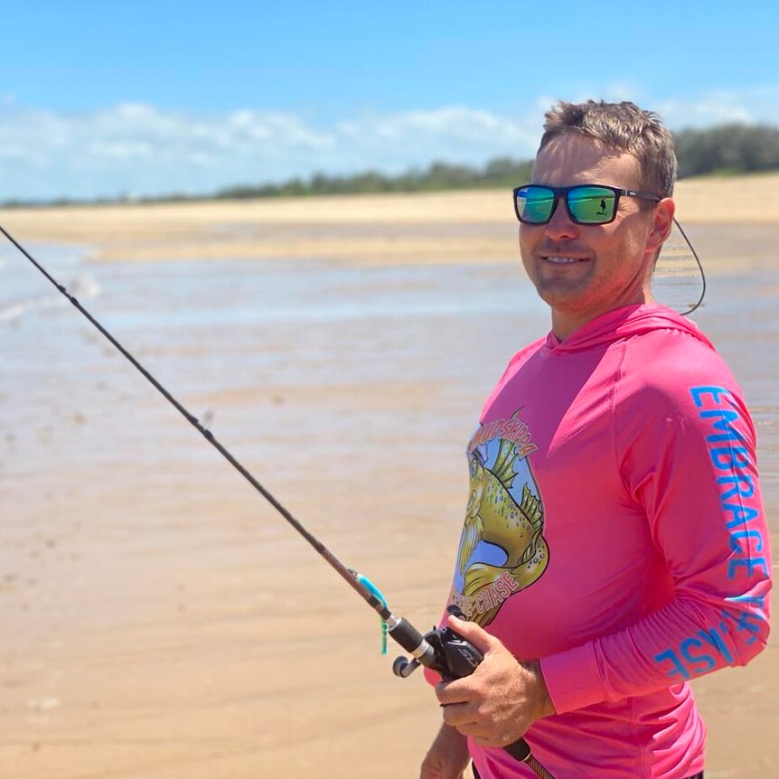 Brent Stephenson standing on a beach holding a fishing line