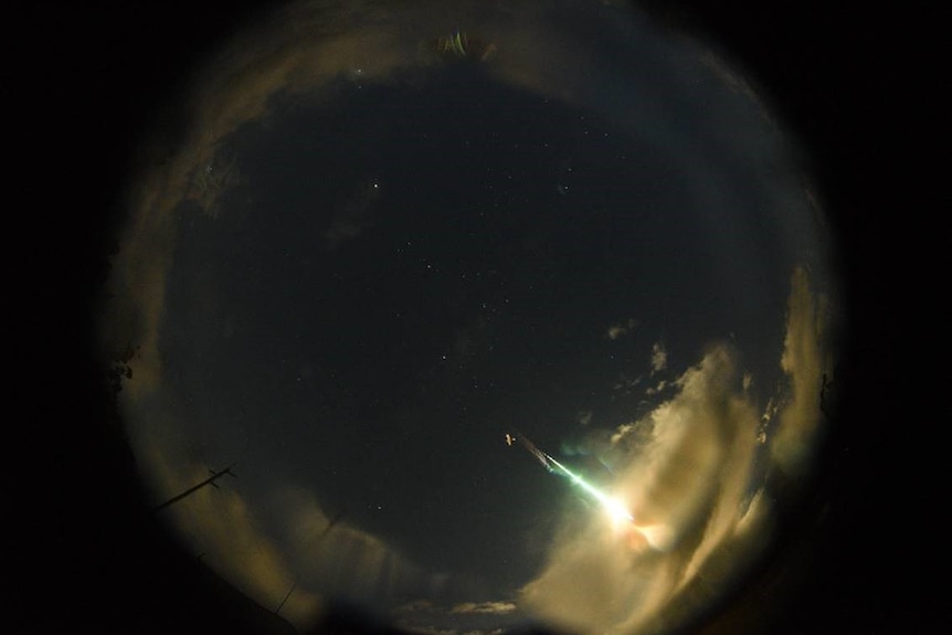 A wide image of the sky showing the meteor or fireball in the distance.