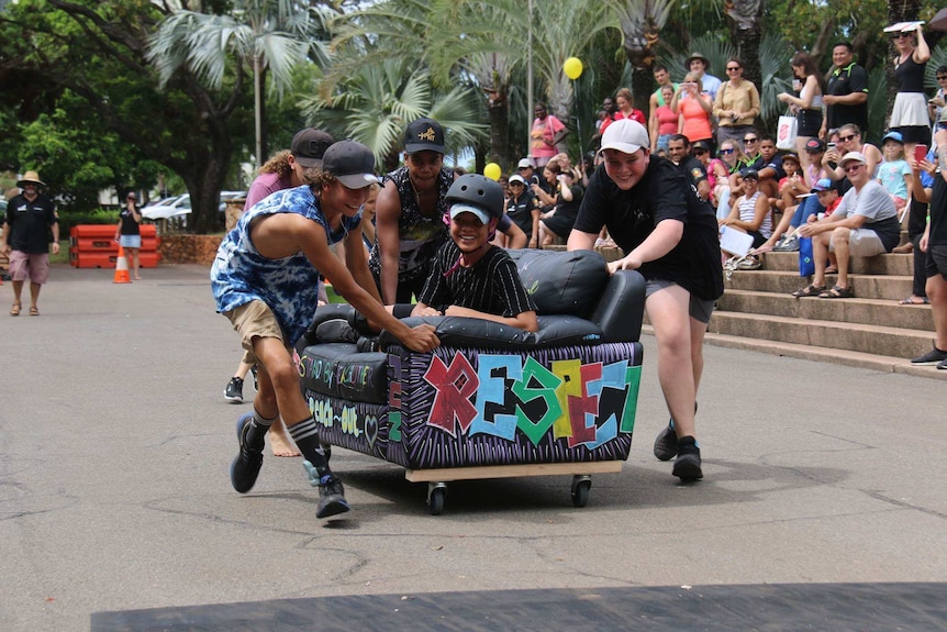 Kids race on a couch through the streets of Darwin