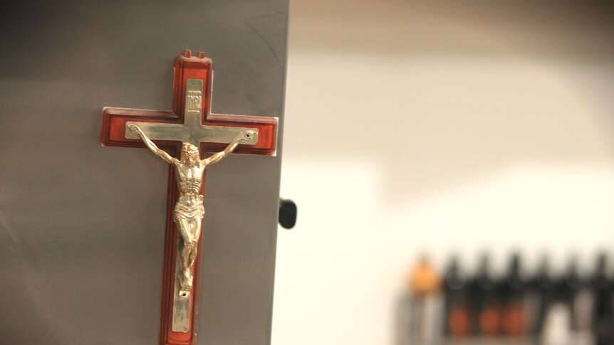 A crucifix hanging in the laser tattoo removal studio.
