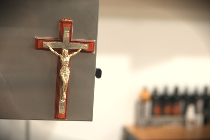 A crucifix hanging in the laser tattoo removal studio.