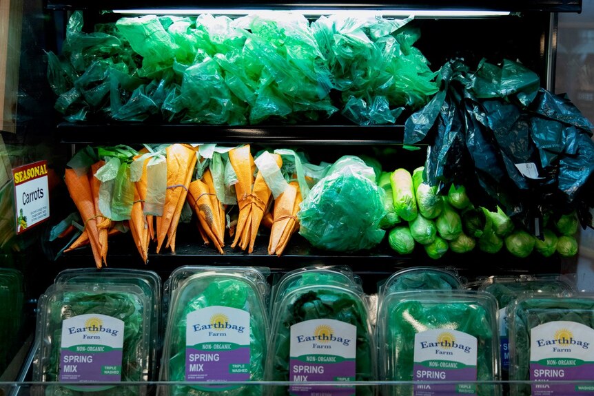 Plastic bags styled as vegetables in a groceries fridge.