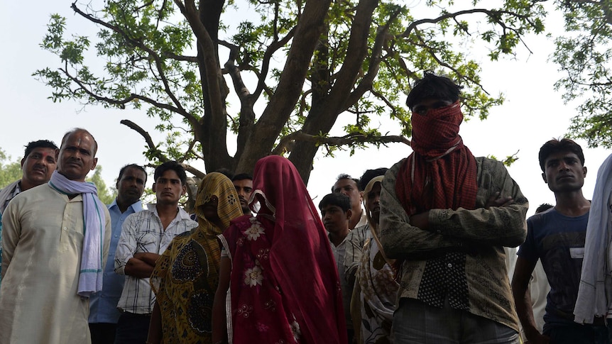Family and friends of girls who were found hanging from a tree in India