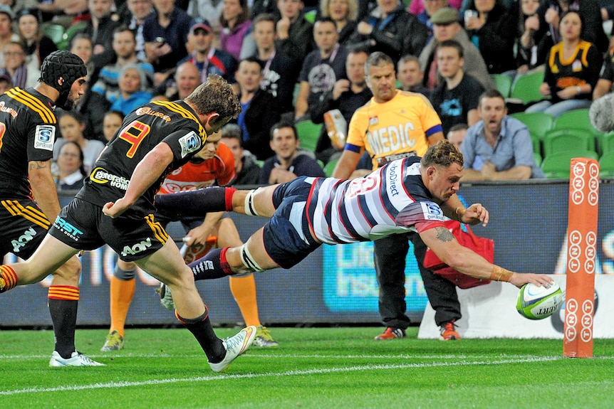 Scott Higginbotham dives over the tryline for the Rebels