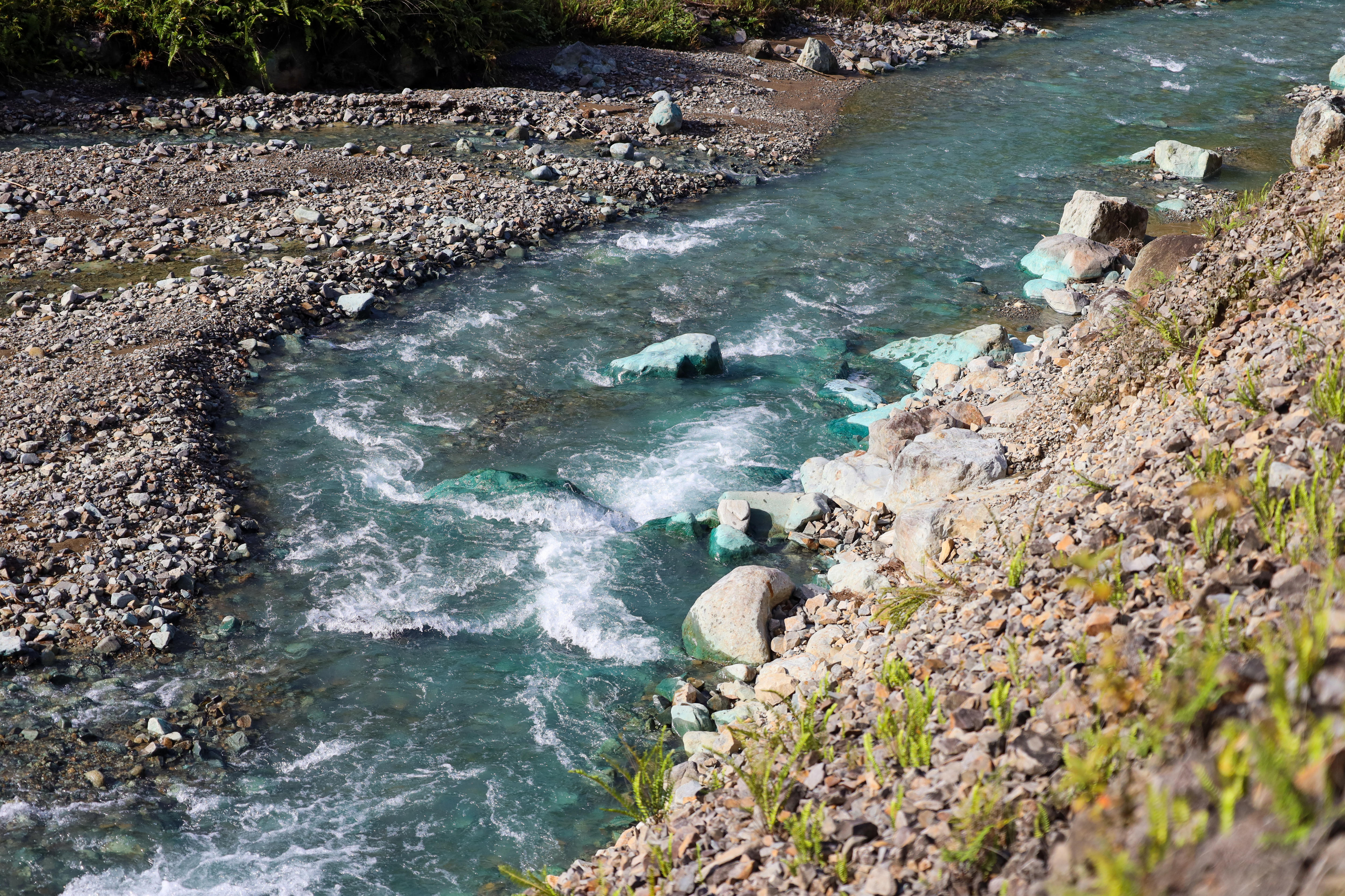 A close up of blue tinged water surrounded by rocks.
