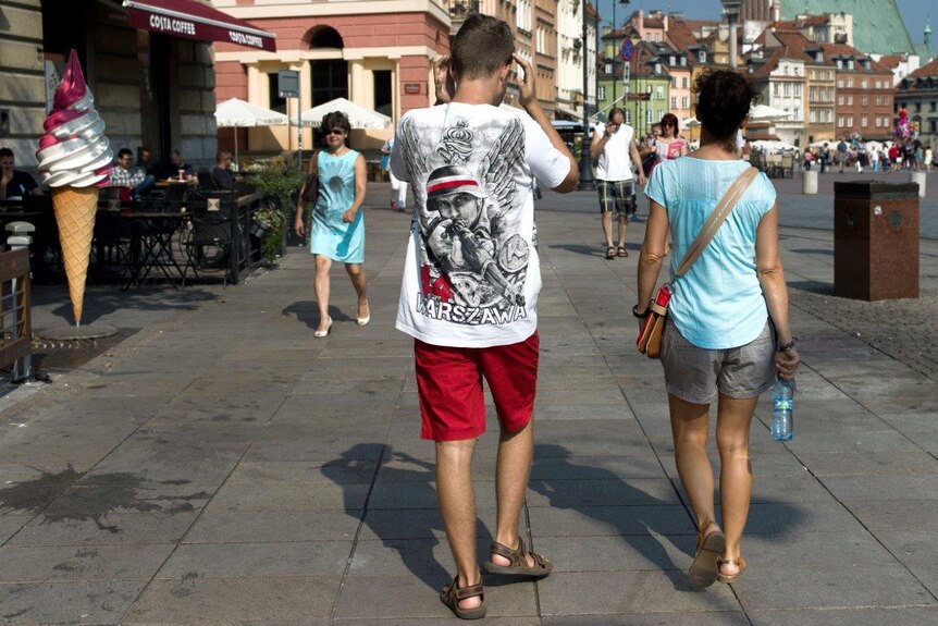 A teenager in Warsaw wearing a Warsaw Uprising T-Shirt.