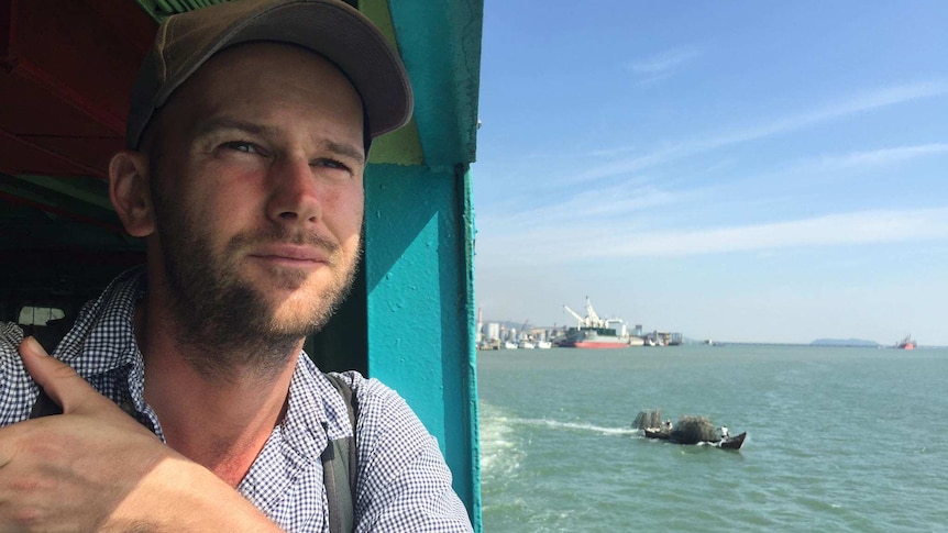 Travel blogger Michael Turtle looks out a ferry window as he arrives in Penang by boat. He manages his mental health while away.