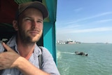 Travel blogger Michael Turtle looks out a ferry window as he arrives in Penang by boat. He manages his mental health while away.