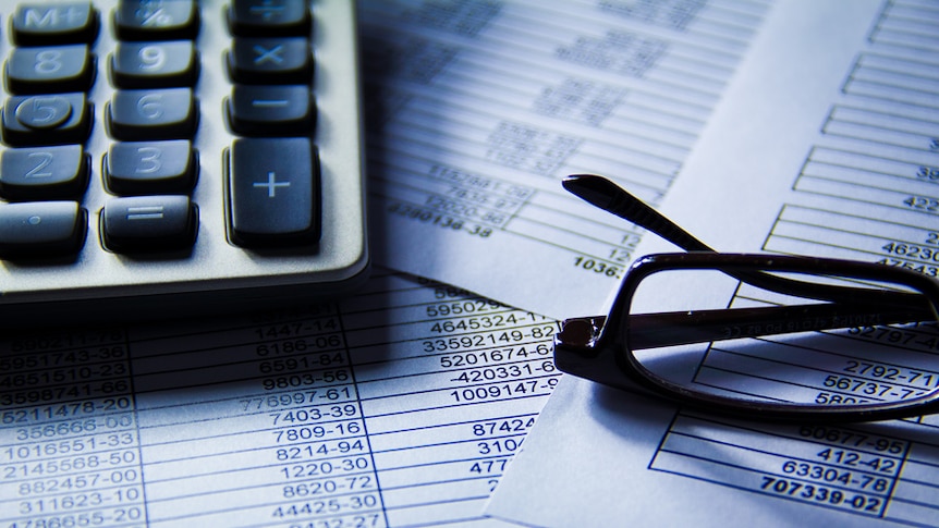 Glasses and a calculator on accounting documents.