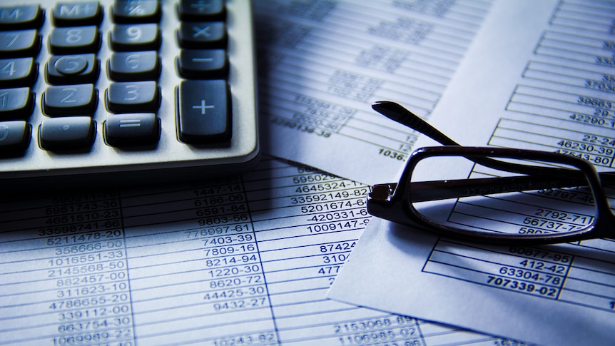 Glasses and a calculator on accounting documents.