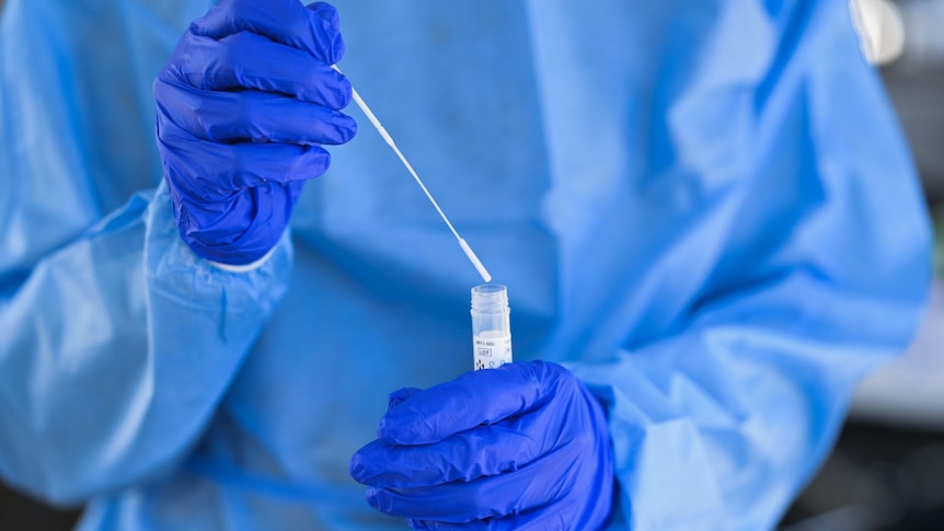 Close-up of a health worker holding a swab and tube for a COVID test in Brisbane on August 4, 2021.