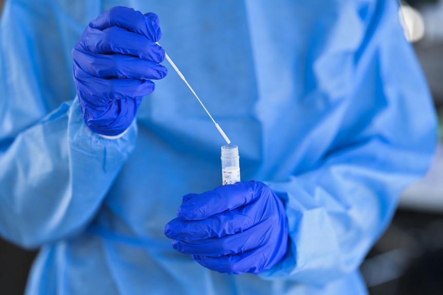 Close-up of a health worker holding a swab and tube for a COVID test in Brisbane on August 4, 2021.