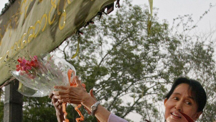 Aung San Suu Kyi accepts flowers from supporters