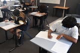 students sitting in a classroom at desks doing a test