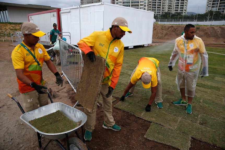 Workers lay turf on the Rio 2016 golf course.