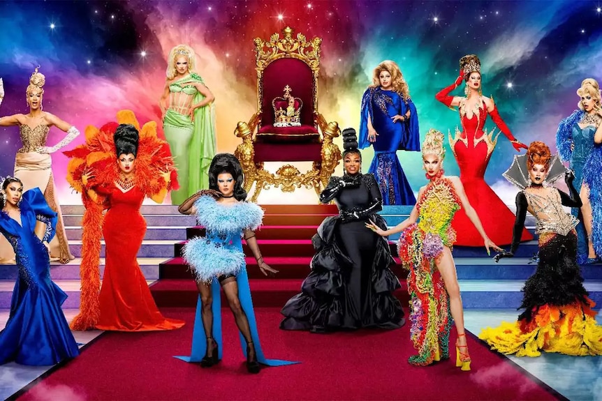 The cast of UK vs The World season two, posing against a red carpet and staircase leading to a royal chair with a crown.