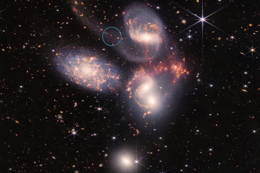 Stephan's Quintet with a wispy tail of dust and stars circled.