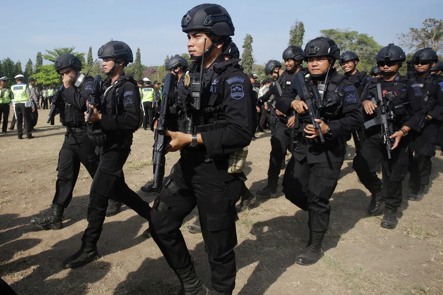 Police officers with guns march during a security parade in preparation for the IMF-World Bank in Bali.