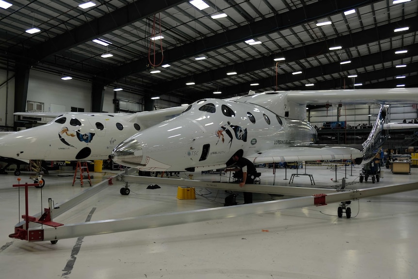 Two reusable SpaceShipTwo space planes inside a hangar
