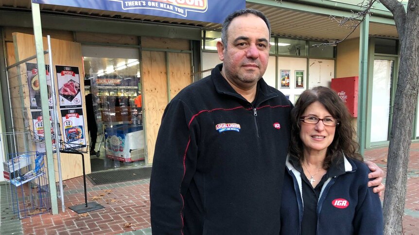 The couple stands out the front of their IGA store.