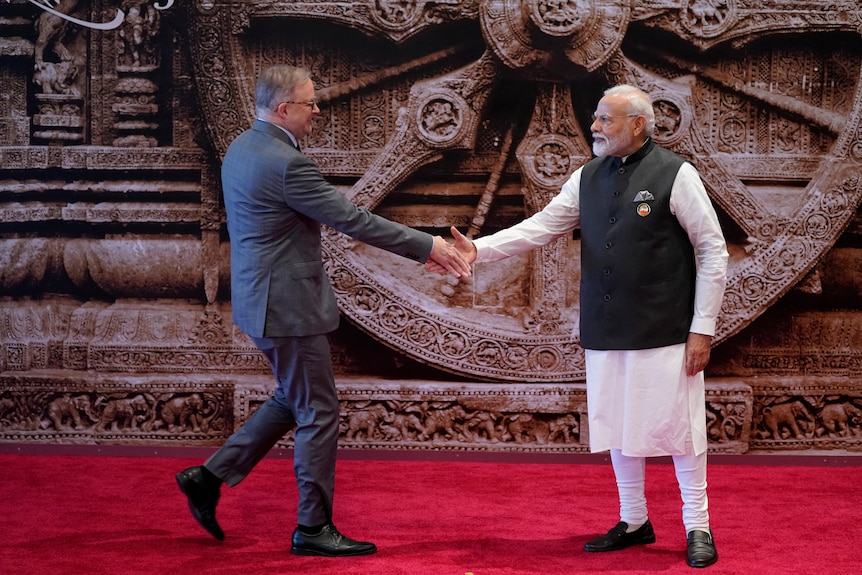 Anthony Albanese and Narendra Modi shake hands. 