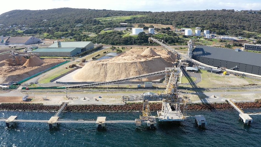 A drone shot showing a woodchip pile next to a port.
