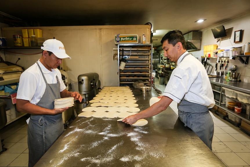 Apprentice Jimmy Van (left) with Chan Khun preparing the pastry for pasties.