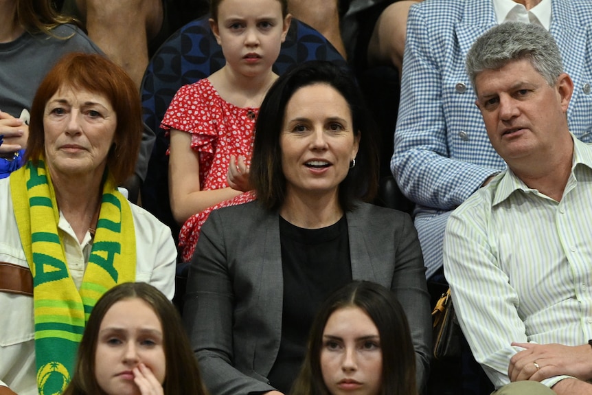 Kelly Ryan wearing a grey blazer and black top sits between a woman with a yellow and green scarf and Stirling Hinchliffe