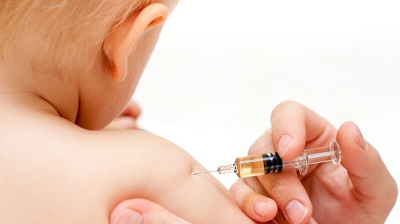 A baby being given a jab from a needle