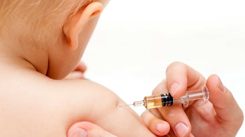 A baby being give a vaccine.