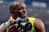 Usain Bolt uses a photographer's camera to take photos after he won the men's 200m final.
