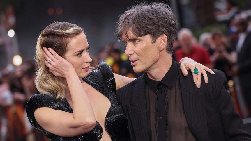 Hollywood stars Emily Blunt and Cillian Murphy with arms around each other on Oppenheimer premiere red carpet