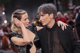 Hollywood stars Emily Blunt and Cillian Murphy with arms around each other on Oppenheimer premiere red carpet