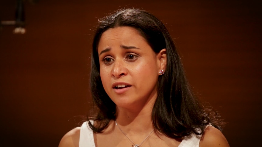 A portrait of a person singing in a recording studio