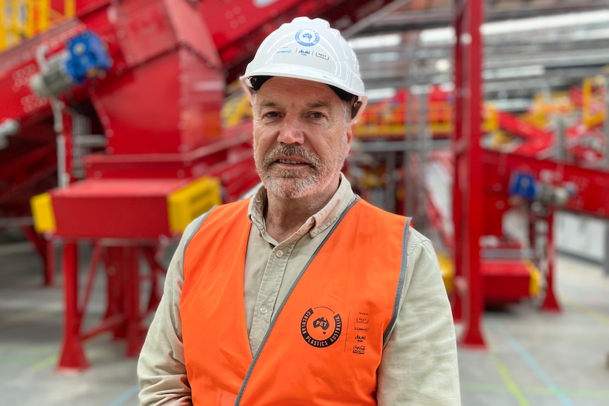 man in hard hat standing in front of machinery