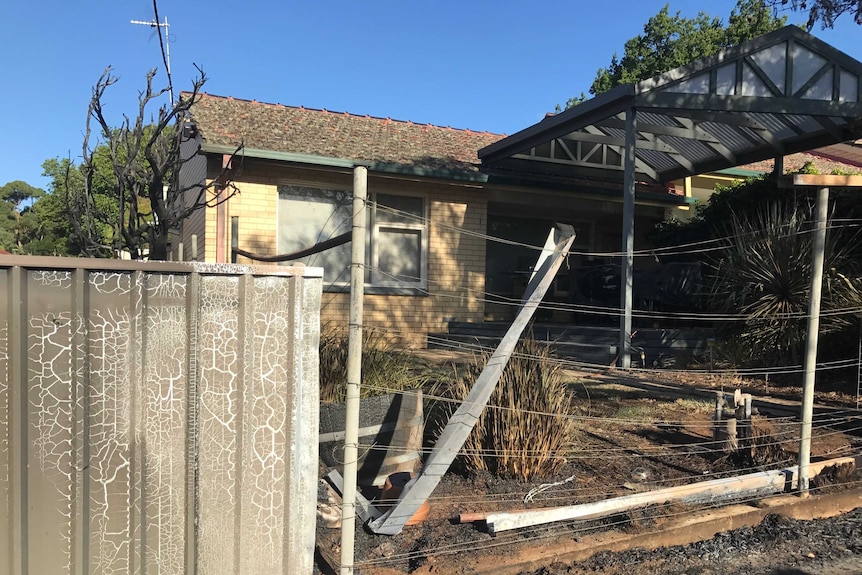 A burnt fence in front of a house